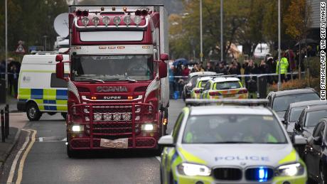 Police officers drive away the lorry in which 39 dead bodies were discovered.