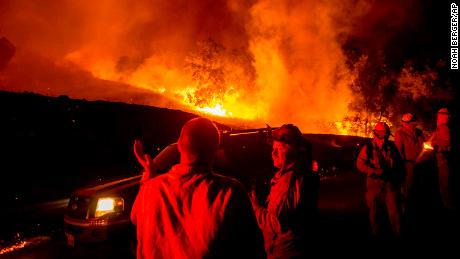 Firefighters confer while battling the Kincade Fire near Geyserville, California, on Thursday.