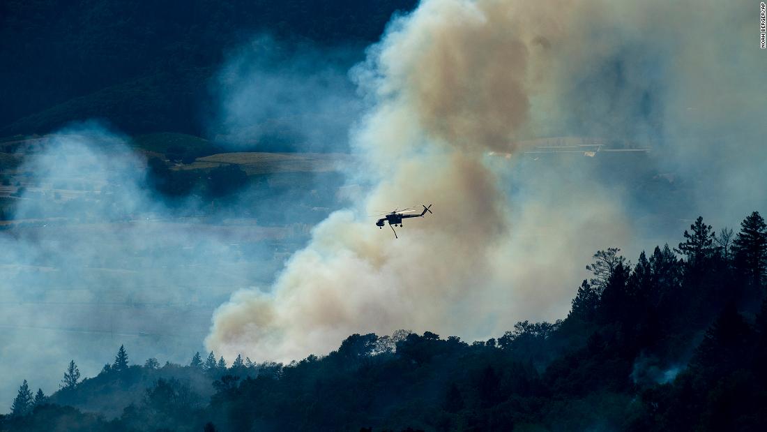 A helicopter passes a smoke plume on October 24. 