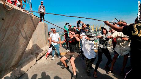 Anti-government protesters pull down concrete walls leading to the heavily guarded Green Zone.