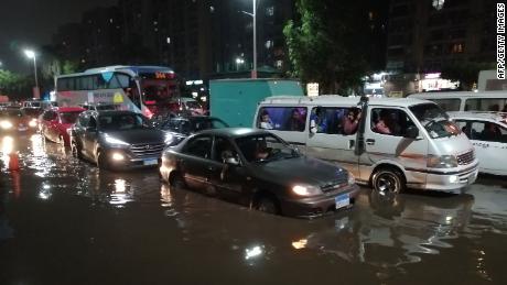 Cars drive on a flooded street following rainfall that led to traffic jam in the Heliopolis district in the Egyptian capital Cairo on October 22, 2019.