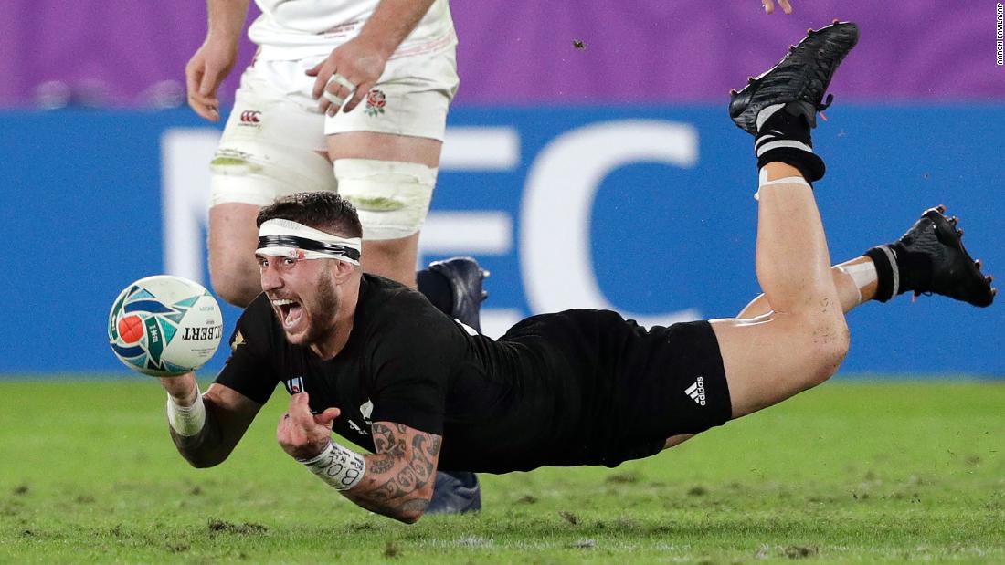 New Zealand&#39;s TJ Perenara passes the ball before he hits the ground during the semifinal against England.