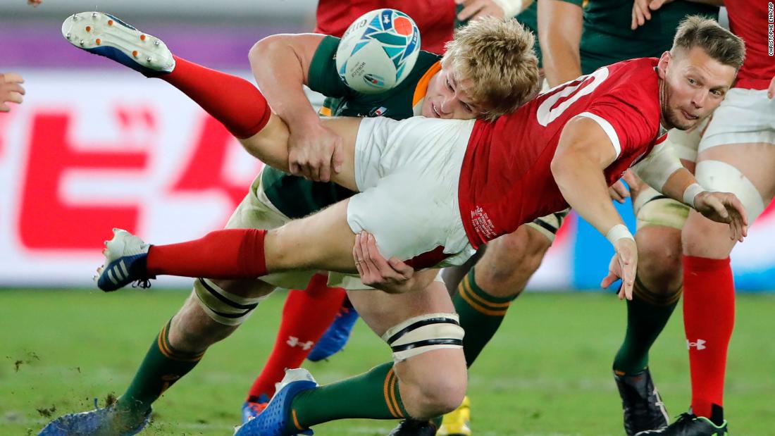 Wales&#39; Dan Biggar passes the ball as he is tackled by Du Toit during the Rugby World Cup semifinal.