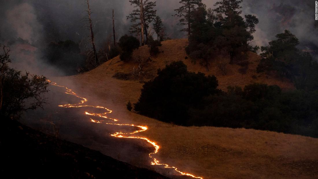 A line of fire snakes along a hillside as firefighters light backfires to slow the spread of the Kincade Fire near Geyserville, California, on October 26.