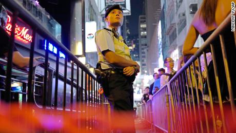 A police officer stands guard as people celebrate Halloween in Lan Kwai Fong in 2017.