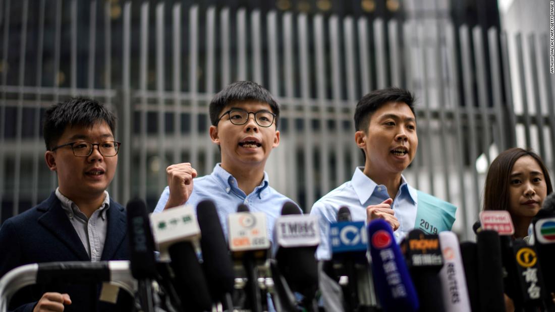 Pro-democracy activist Joshua Wong (second from left) and Kelvin Lam (second from right) shout slogans as they meet the media outside the Legislative Council (LegCo) in Hong Kong on October 29, 2019, after Wong was barred from standing in an upcoming local election.