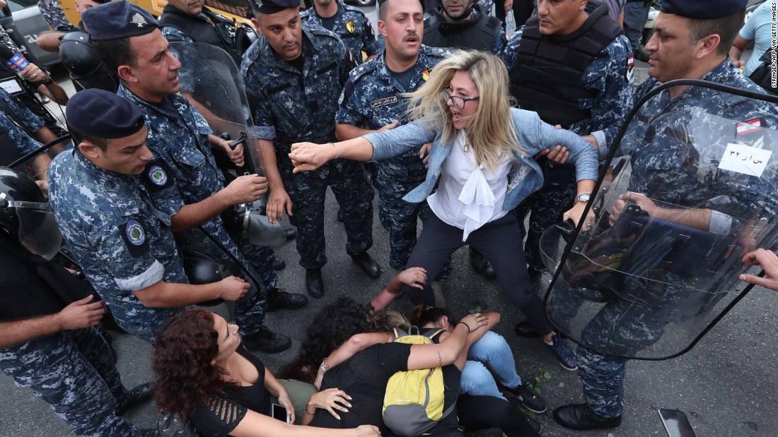 A Lebanese demonstrator scuffles with security forces trying to disperse protesters who were blocking a major bridge in Beirut on Sunday, October 27.