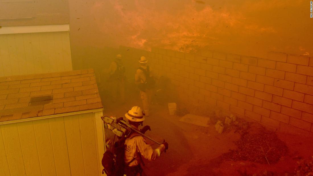 Flames approach the backyards of mobile homes in Jurupa Valley, California, on October 30.