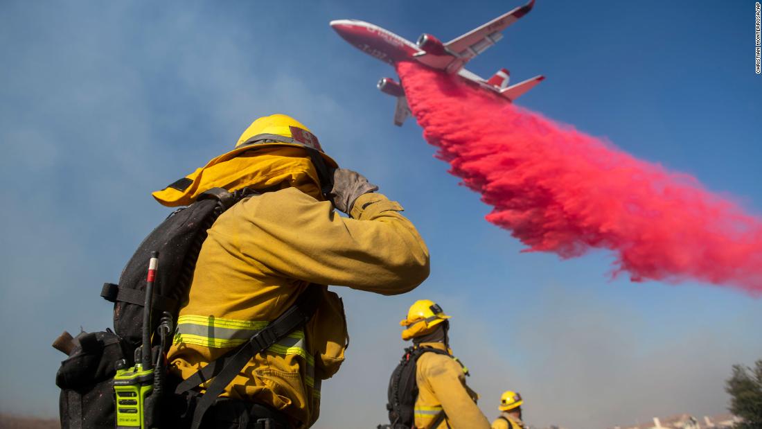 Firefighters brace themselves for incoming fire retardant as they battle the Easy Fire in Simi Valley.