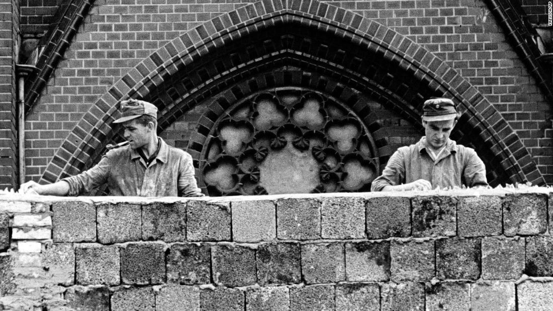 East German workers embed broken glass in the top of the Berlin Wall on August 22, 1961, shortly after construction began.  