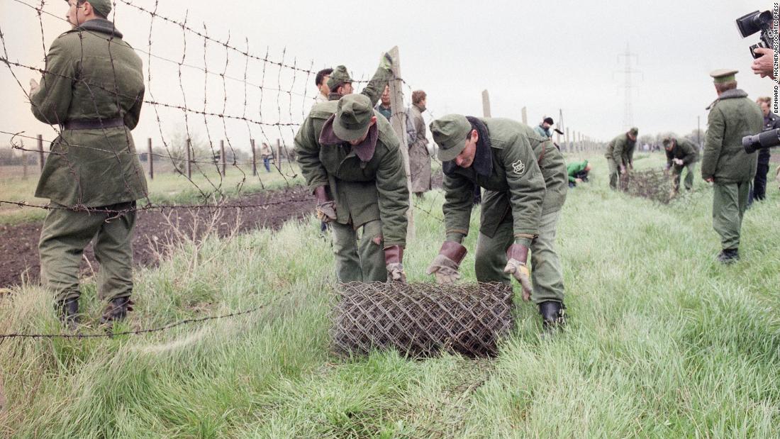 Hungarian border guards begin dismantling the &quot;Iron Curtain&quot; in May 1989, opening the country&#39;s border with Austria.