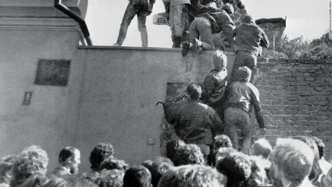 East German citizens scale the walls of the West German embassy in Prague in October 1989, in a desperate first step to freedom.