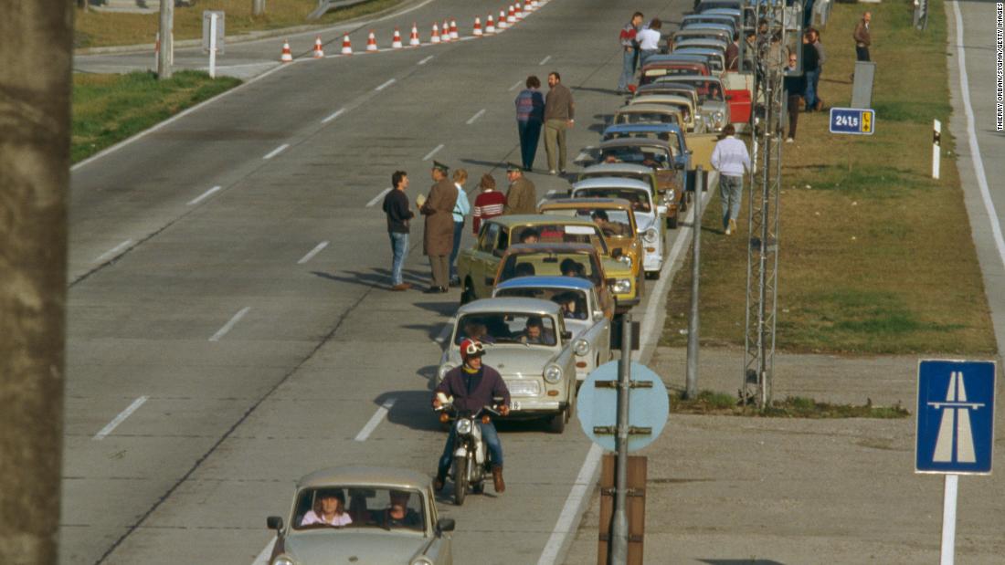 A line of East Germany&#39;s famous Trabant cars heads West along a highway near Leipzig, following the fall of the Wall.