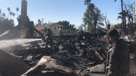 Matthew Valdivia stands in front of the burned wreckage of his house in San Bernardino.