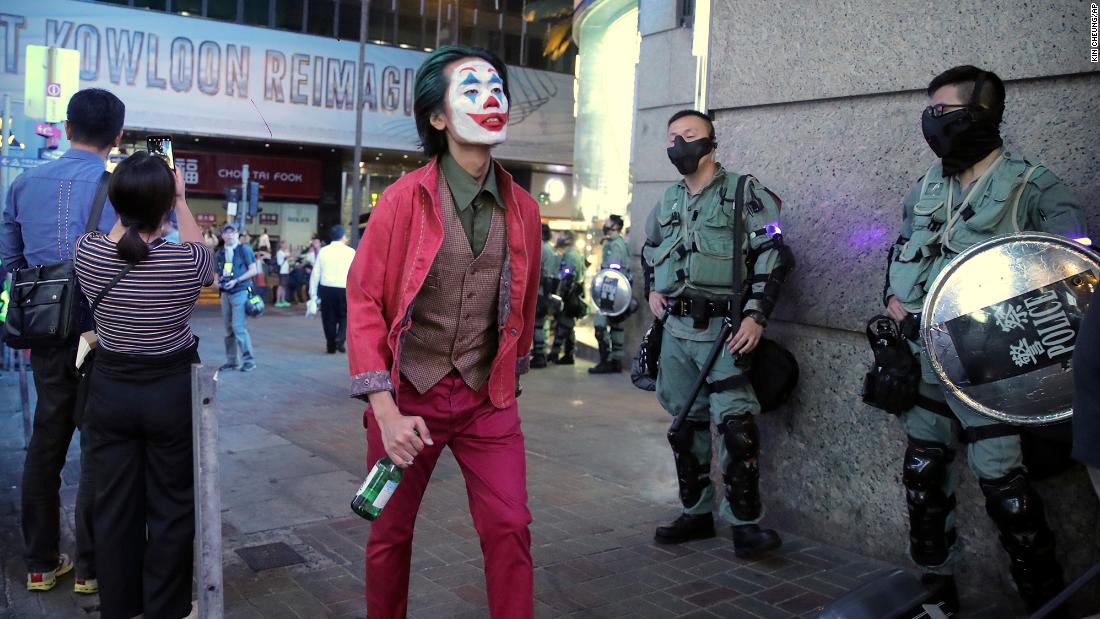 A man dressed as the Joker for Halloween walks past police officers on October 31. 
