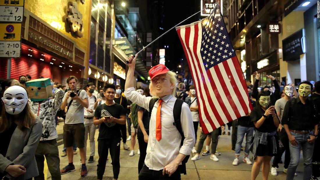 A person dressed as President Donald Trump waves an American flag on a street in Hong Kong on Thursday, October 31, 2019. Hong Kong authorities braced as pro-democracy protesters urged people on Thursday to celebrate Halloween by wearing masks on a march in defiance of a &lt;a href=&quot;https://www.cnn.com/2019/10/30/asia/halloween-hong-kong-mask-ban-intl-hnk/index.html&quot; target=&quot;_blank&quot;&gt;government ban on face coverings&lt;/a&gt;. 