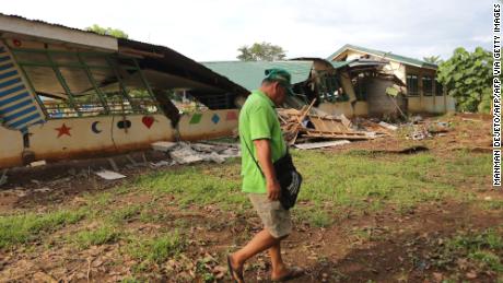 A resident walks past a collapsed school building after a 6.6-magnitude earthquake hit Tulunan town, North Cotabato province, on the southern island of Mindanao on October 29, 2019.