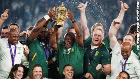 South Africa&#39;s President Cyril Ramaphosa (centre R) and Kolisi (centre L) lift the trophy.