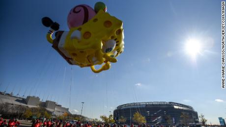 A SpongeBob SquarePants and Gary balloon flies in front of Metlife Stadium