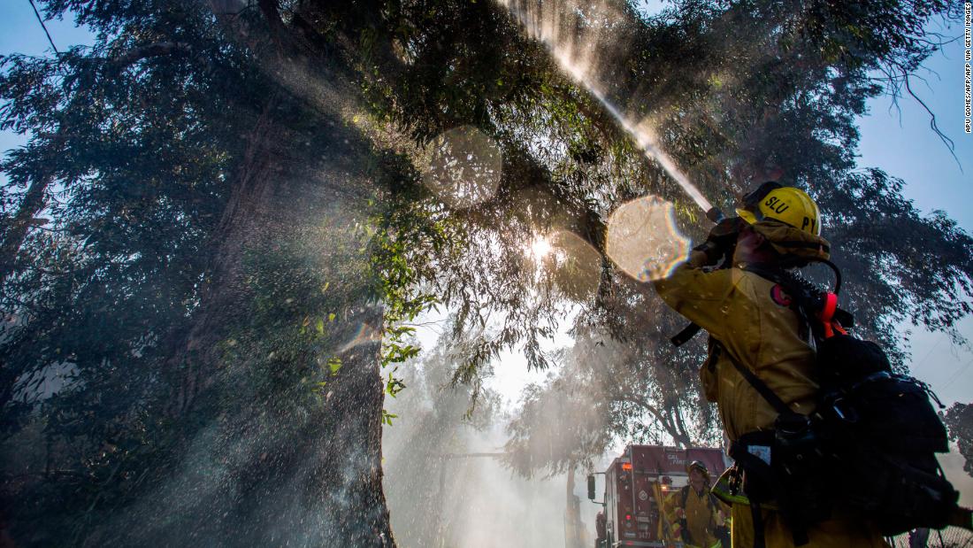 Firefighters spray water onto a tree while fighting the Maria Fire in Ventura County, California, on November 1.