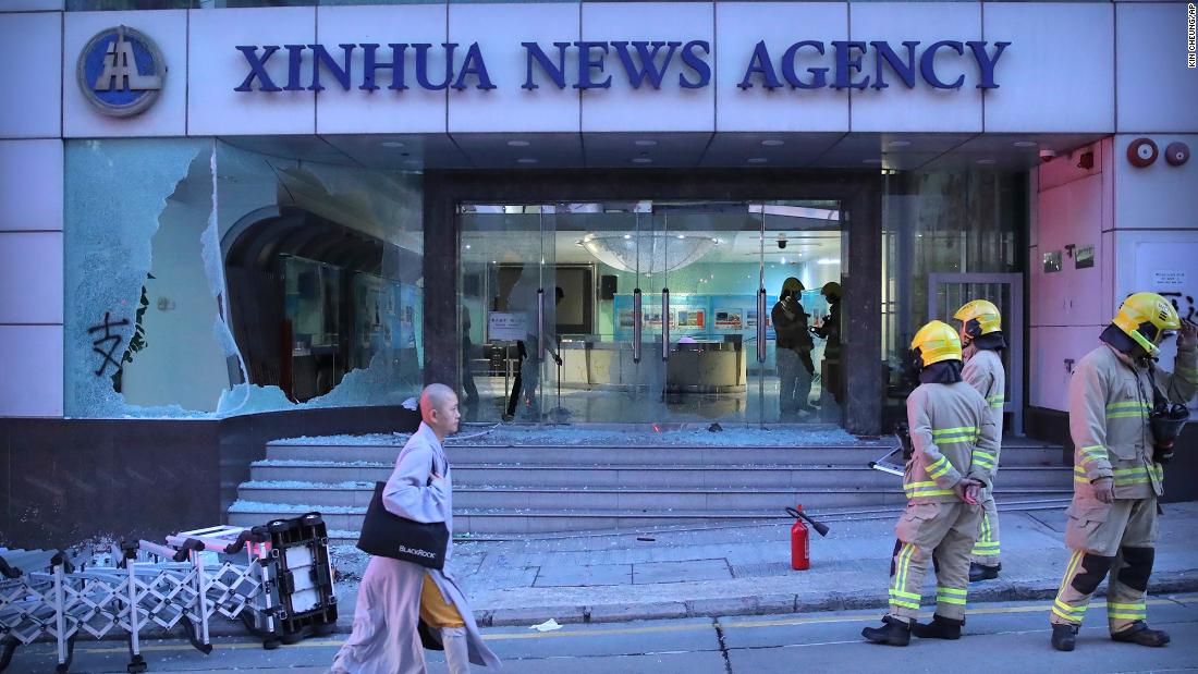 Firefighters stand outside the offices of China&#39;s Xinhua News Agency after its windows were damaged by protesters in Hong Kong on Saturday, November 2. Hong Kong riot police fired multiple rounds of tear gas and used a water cannon Saturday to break up a rally by thousands of masked protesters demanding autonomy after Beijing indicated it could tighten its grip on the Chinese territory.