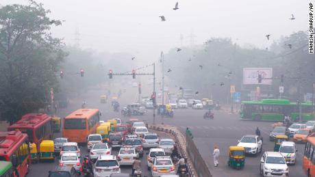Vehicles wait at a crossing amid morning smog in New Delhi on Sunday.