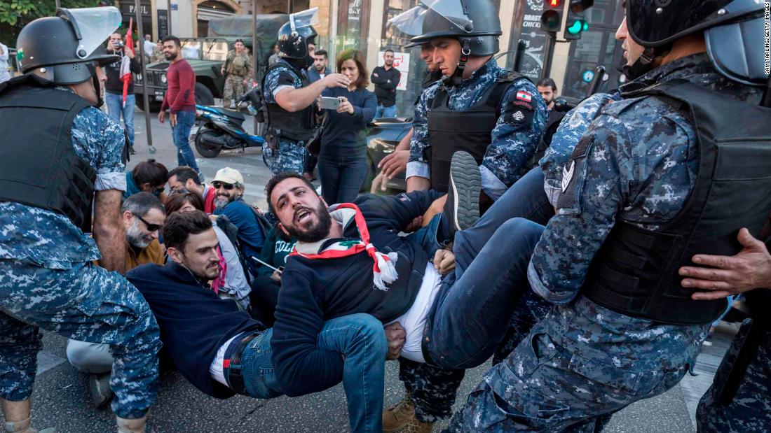 Riot police remove anti-government protesters who were occupying an intersection in Beirut, Lebanon, on Monday, November 4.