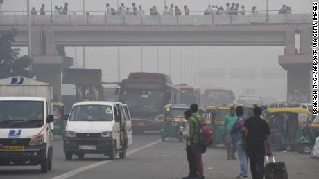 People make their way on a street in smoggy conditions in New Delhi on November 4, 2019.