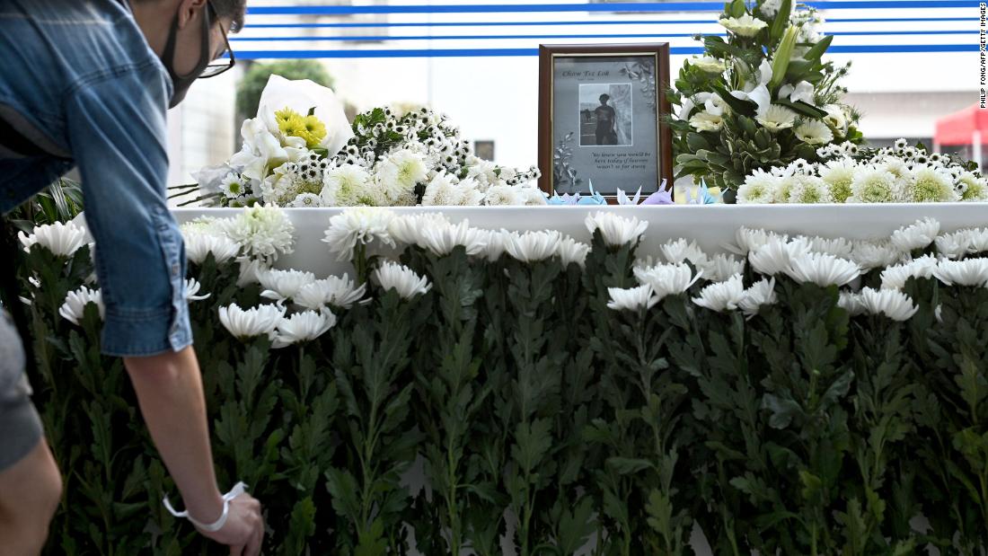 A person places a flower at a memorial for 22-year-old Hong Kong university student Chow Tsz-lok on November 8.