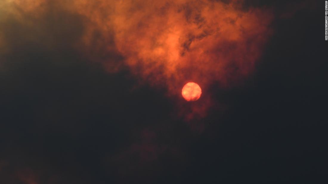 The sun is seen through heavy smoke as a bushfire burns in Woodford.