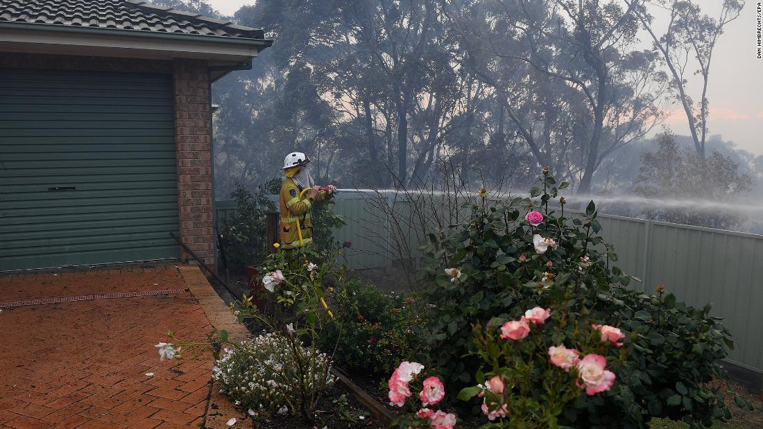 Firefighters hose down an area in Woodford.