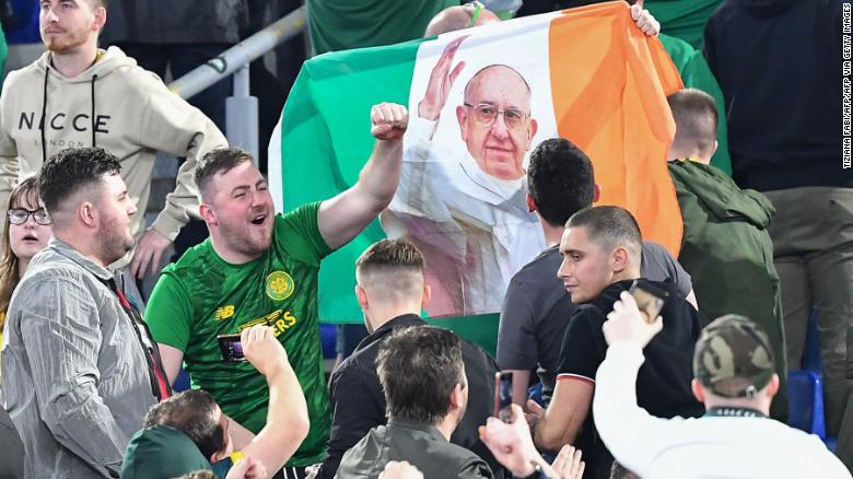 Celtic fans wave the flag of Ireland with a photo of Pope Francis.