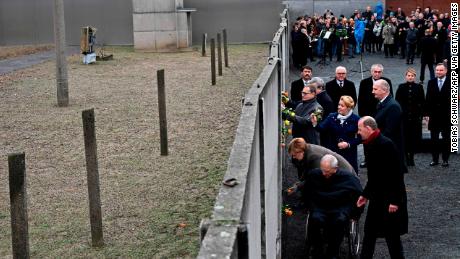 German Chancellor Angela Merkel and others place flowers at the Wall Memorial.