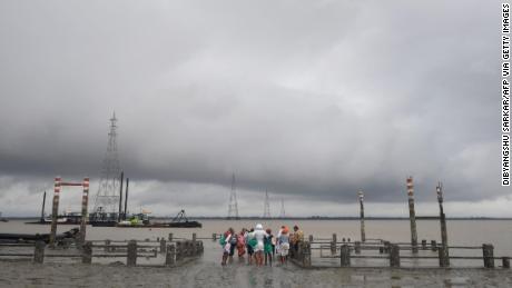 Hindu pilgrims stand by a dock after a ferry service to Sagar Island was suspended due to the approaching Cyclone Bulbul in Kakdwip.