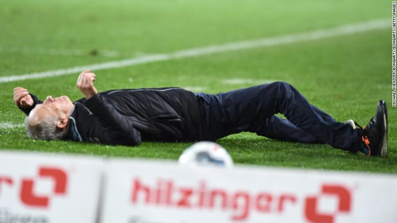 Freiburg manager Christian Streich is knocked to the ground by David Abraham. 