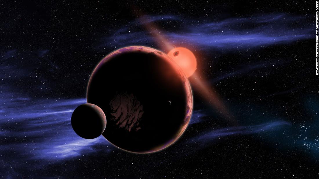 This artist&#39;s concept illustration shows an exoplanet with two moons orbiting within the habitable zone of a red dwarf star. 