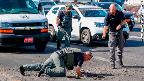 Israeli police inspect a hole in the highway in Ashdod on November 12.