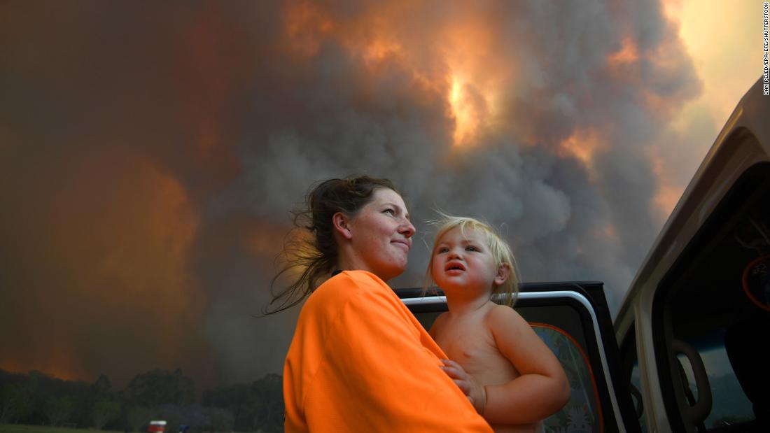 Residents look on as thick smoke rises from bushfires near Nana Glen on November 12.