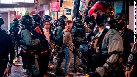 Riot police detain two men after clearing protesters from the central district in Hong Kong.