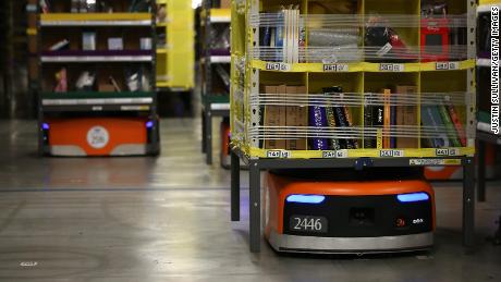 Robots move shelves of merchandise at an Amazon fulfillment center.