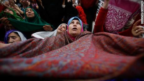 A Kashmiri Muslim woman raises her veil in the air to pray in Srinagar, India, on November 10, 2019. 