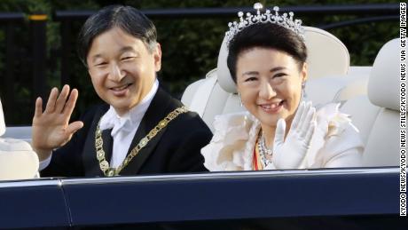 Japanese Emperor Naruhito and Empress Masako wave to the crowd during his enthronement parade from the Imperial Palace to the Akasaka Imperial Residence in Tokyo on November 10, 2019. 