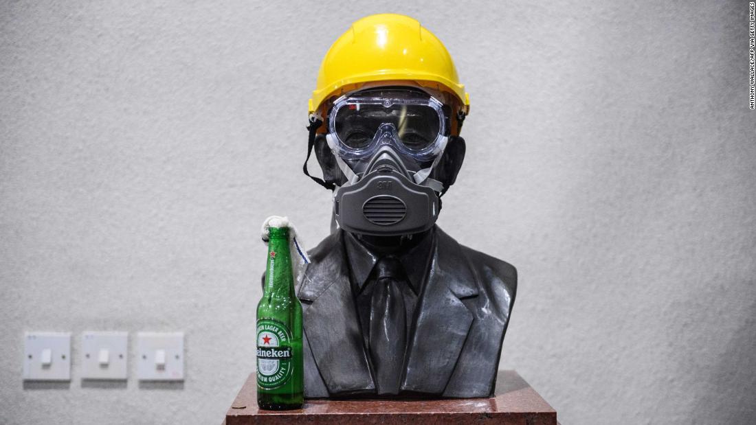 A Molotov cocktail, a gas mask and a yellow construction helmet are placed upon a bust of late hotel tycoon Hui Yeung Shing at the campus of The Chinese University of Hong Kong on November 13.