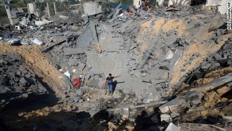 A youth stands in the crater of a destroyed house following overnight Israeli strikes in the Gaza Strip.