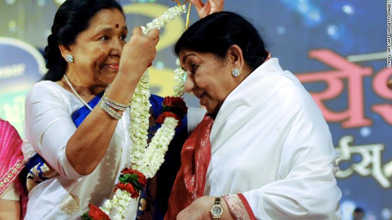 Indian Hindi and Marathi language Bollywood playback singer Lata Mangeshkar (right) is greeted by her sister Asha Bhosle during an awards ceremony in 2013.