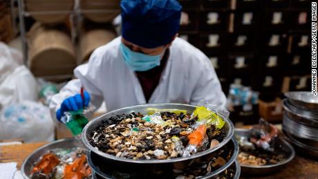 A woman mixes medicine in the pharmacy of the Yueyang Hospital, part of the Shanghai University of Traditional Chinese Medicine, in Shanghai on November 7, 2018. 