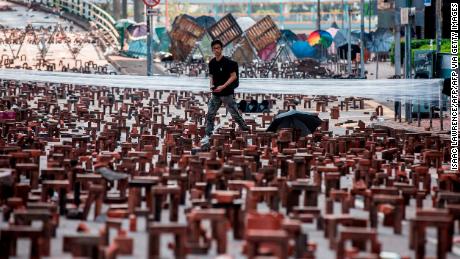 A man walks through bricks placed on a barricaded street outside The Hong Kong Polytechnic University in Hong Kong on November 15, 2019. 