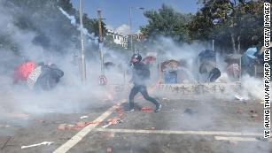 A protester reacts from tear gas fired by police at the Hong Kong Polytechnic University in Hong Kong on Sunday.