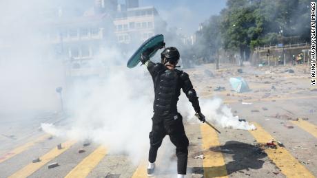 A protester reacts from tear gas fired by police at the Hong Kong Polytechnic University in Hong Kong on Sunday.