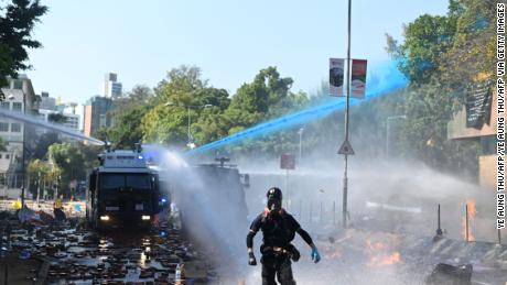 Police launch water cannon and tear gas outside the Hong Kong Polytechnic University to disperse protesters in Hong Kong on Sunday.